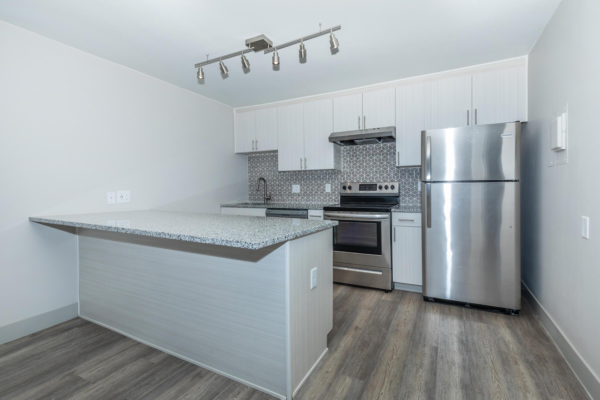 Stainless steel all electric kitchen with dining at the counter at North 49 Apartments, located in Colorado Springs, CO